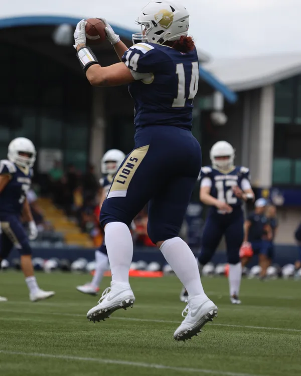 Anna catching an American football while playing for Great Britain